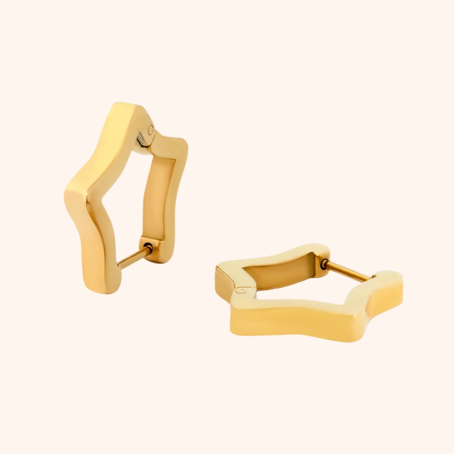 Gold star-shaped huggie hoop earrings in 18k gold plated stainless steel on neutral background